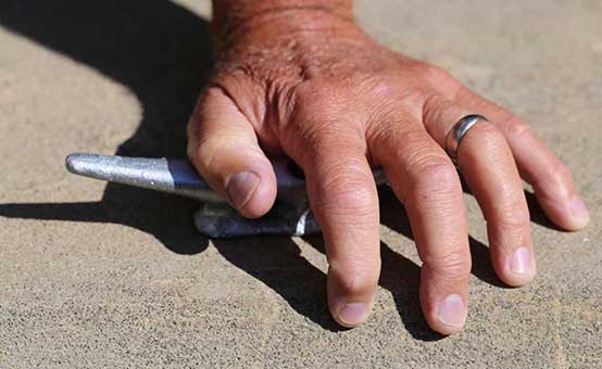 man hand, wearing a ring, holding a boat cleat