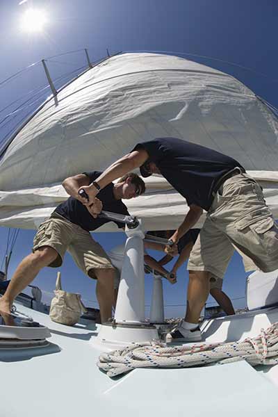 boat crew working a yacht windlass