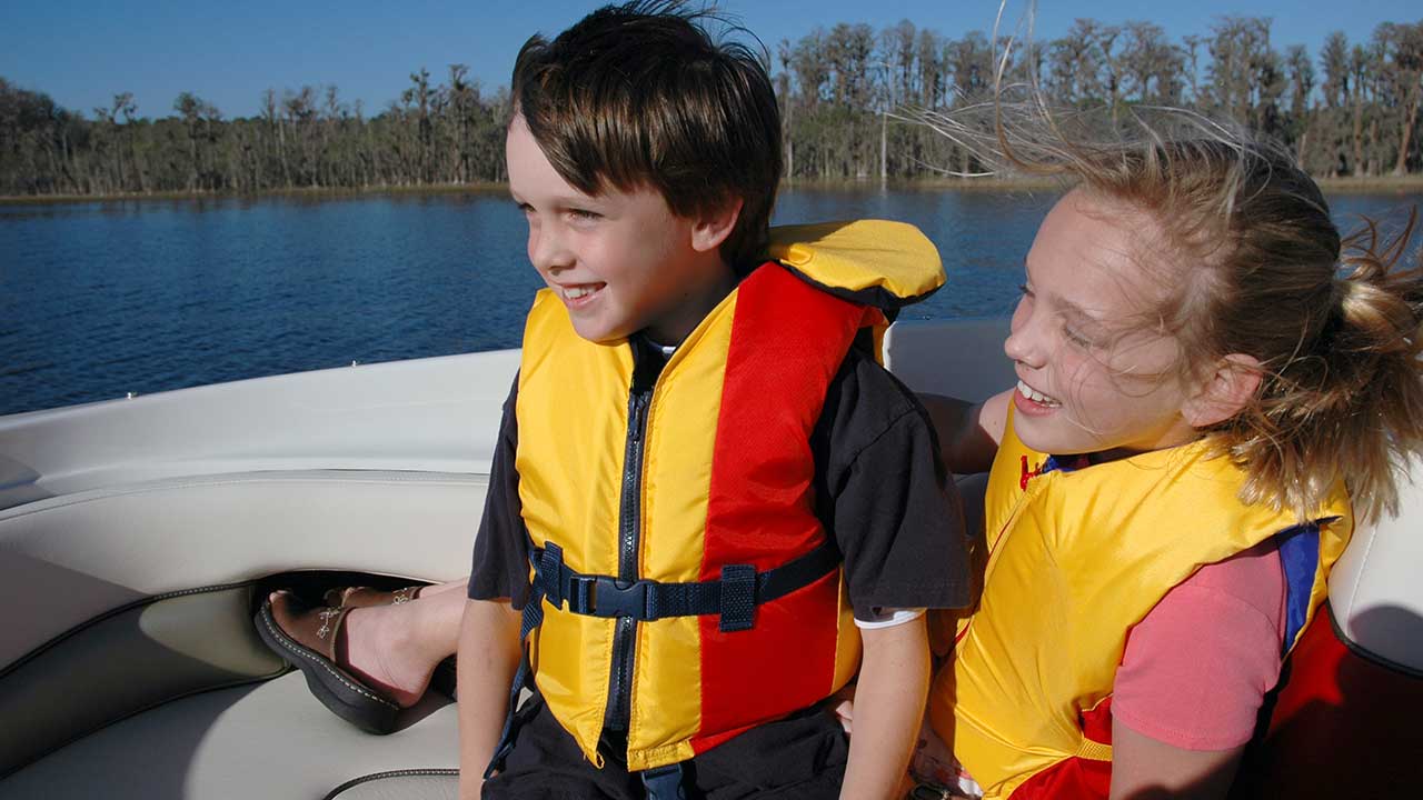 children kids wearing life jackets while boating