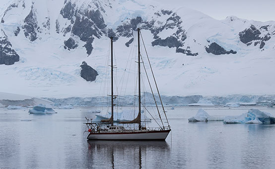 Sailboat cruising through ice and cold water