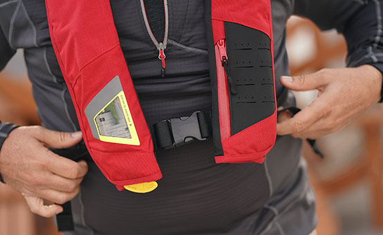 boater inspects the co2 cynlinder in his inflatable life jacket