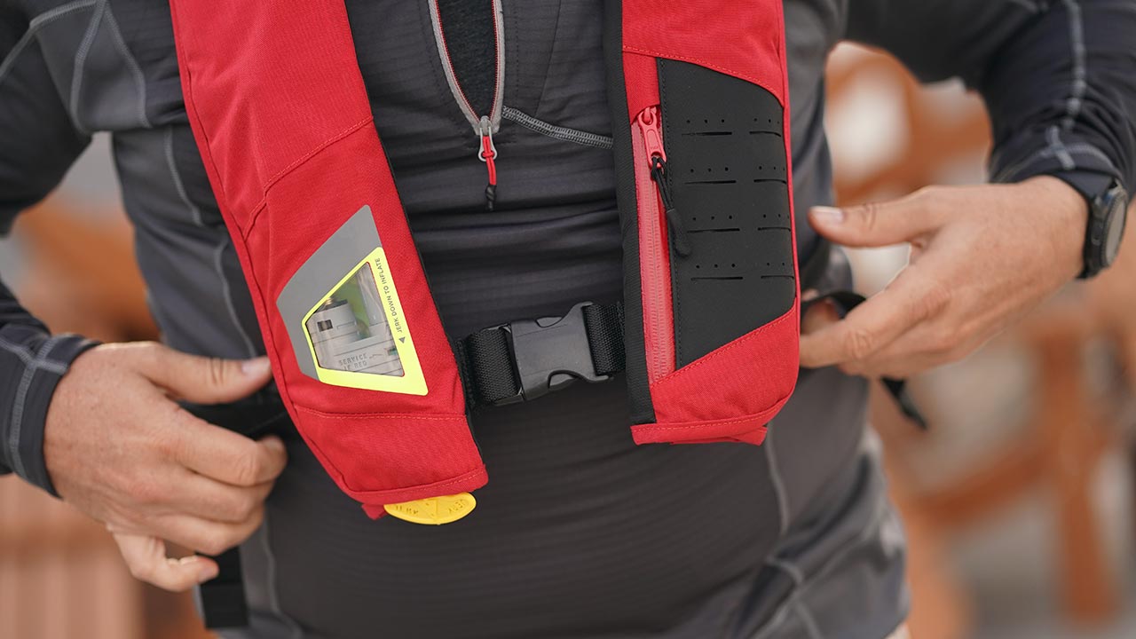 boater inspects the co2 cynlinder in his inflatable life jacket