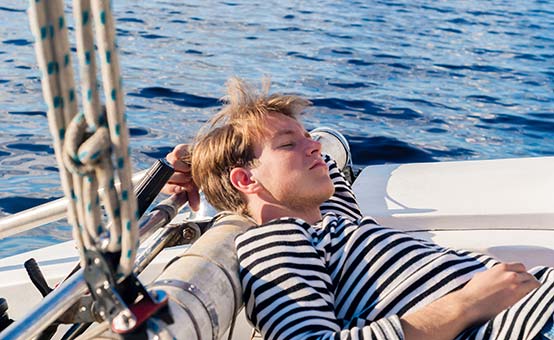 male sailor sleeping aft on the yacht