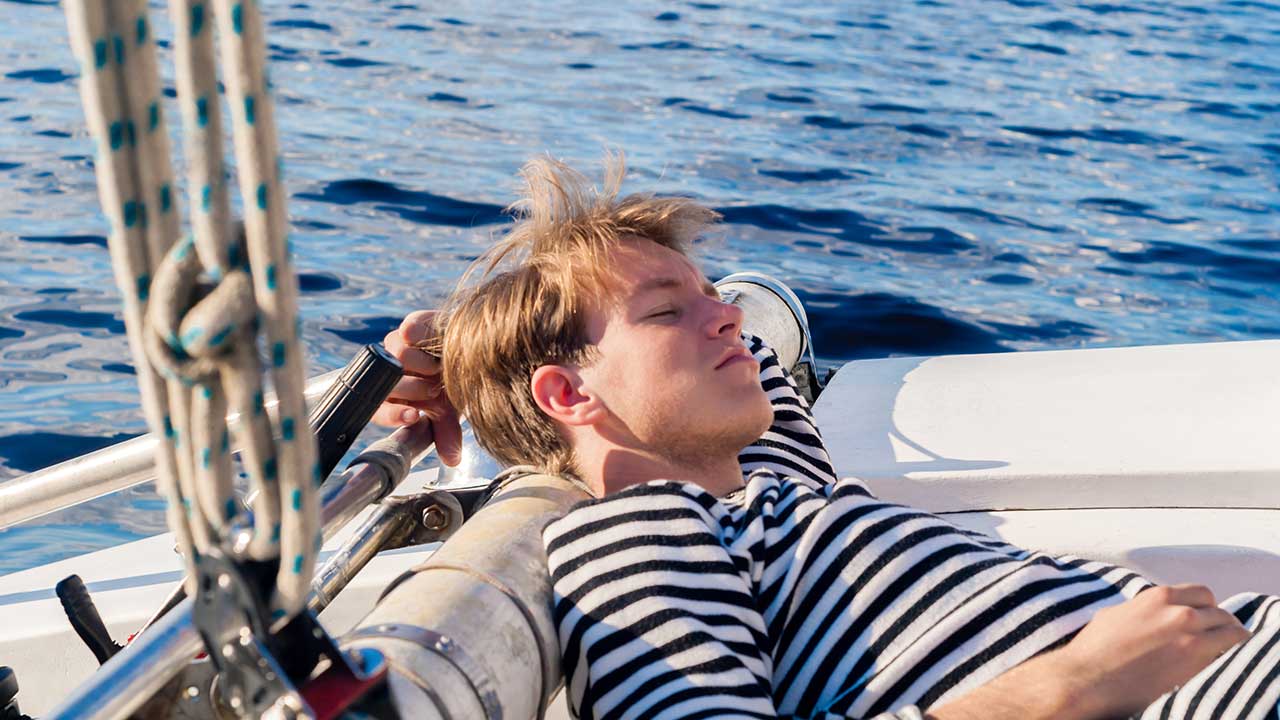 male sailor sleeping aft on the yacht