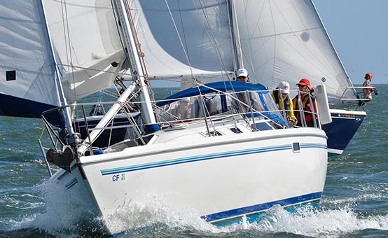 students wear life jackets for safety while taking a sailing course