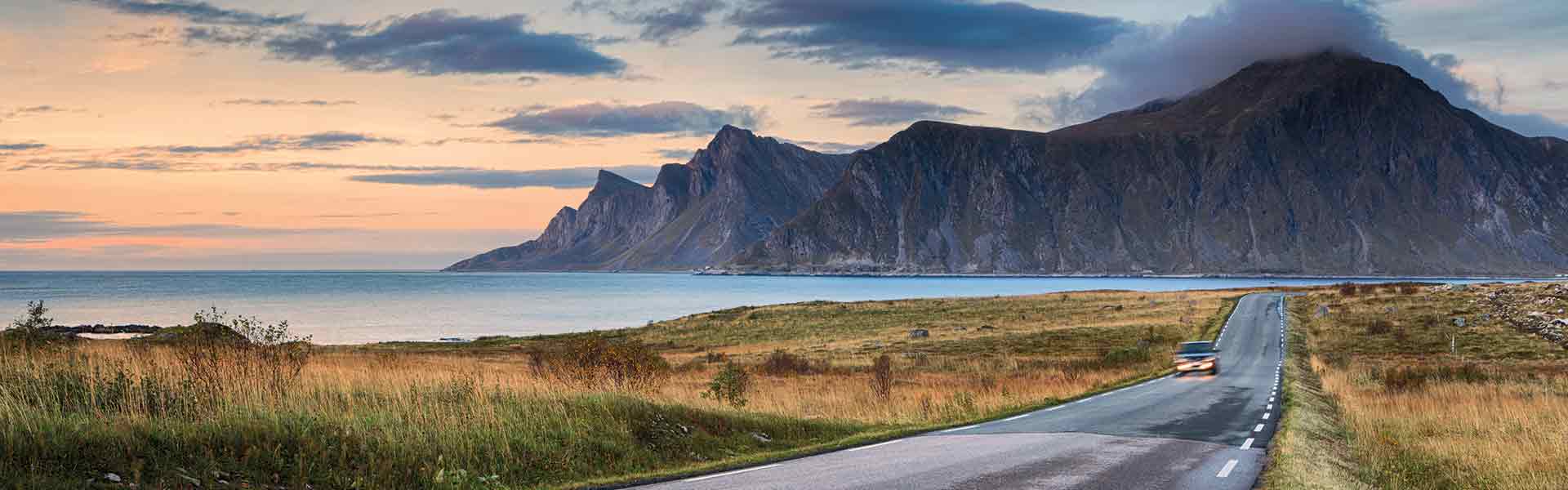 automobile traveling a mountain road in Lofoten Norway at sunset