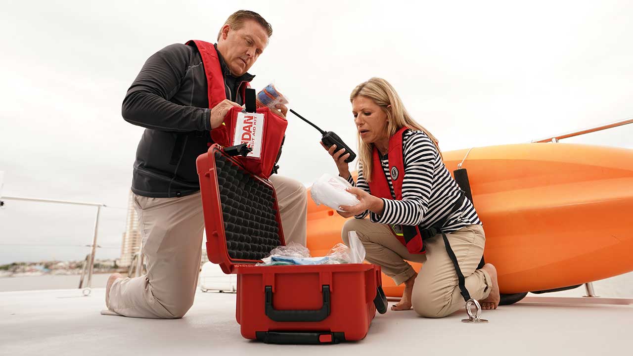 couple on deck of trawler boat inspect first aid kit