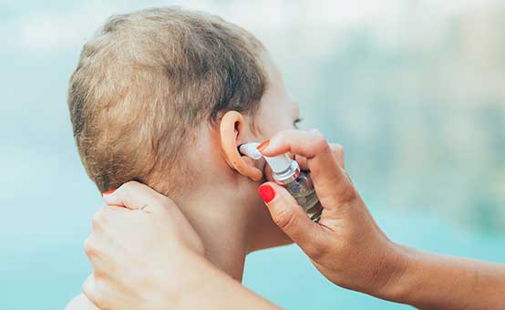 young boy gets eardrops for swimmer's ear